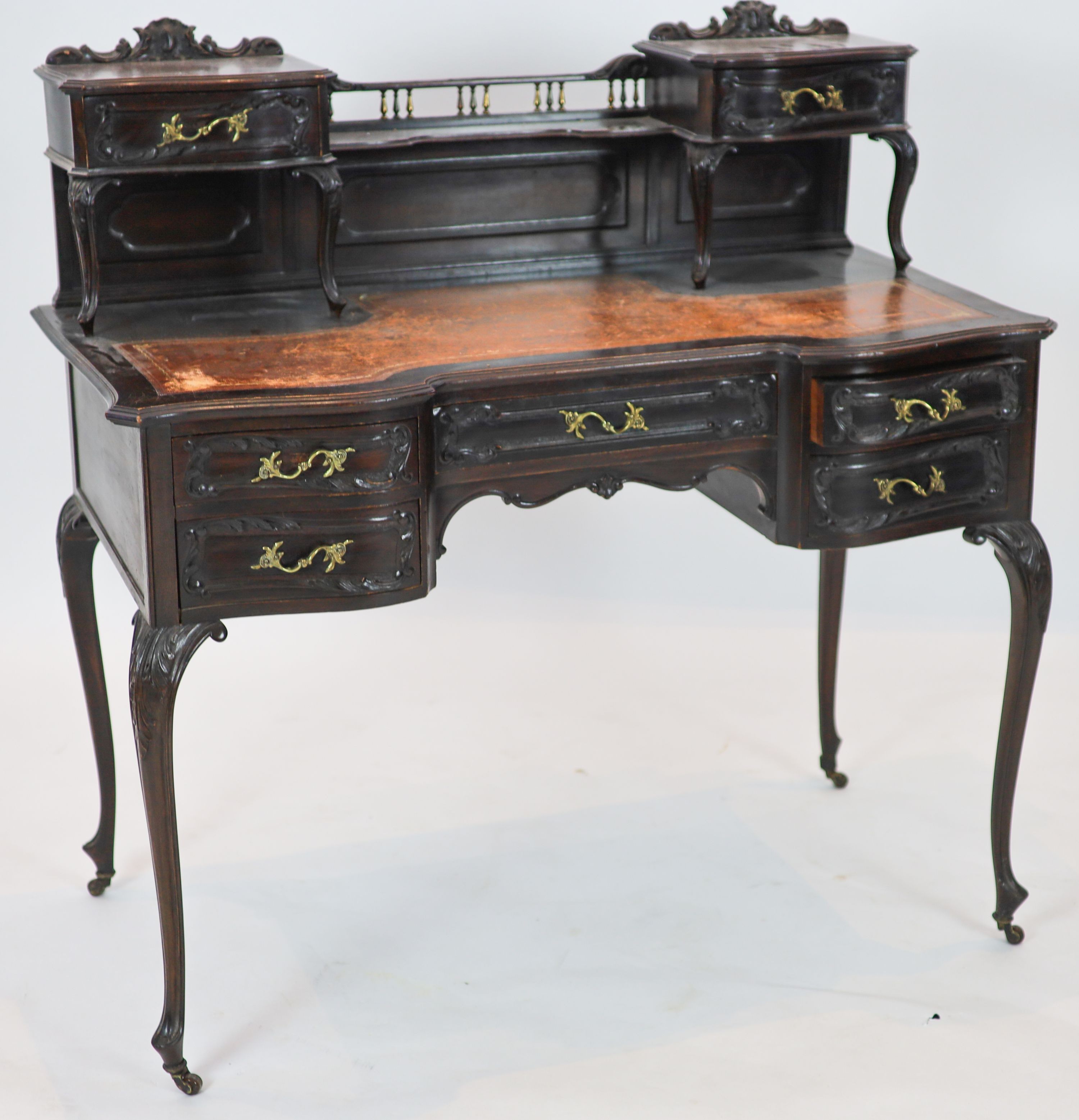 A late Victorian carved mahogany serpentine-shaped writing desk, length 106cm, depth 54cm, height 105cm